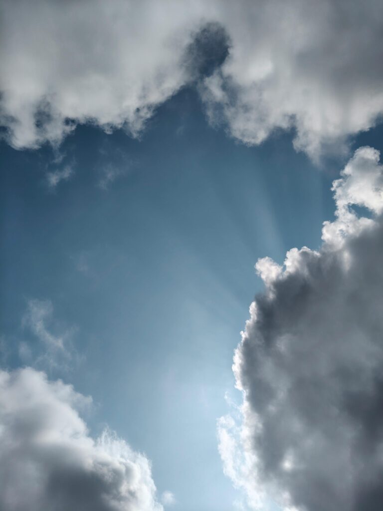A captivating afternoon sky with sunlight rays shining through clouds in Silchar, Assam.