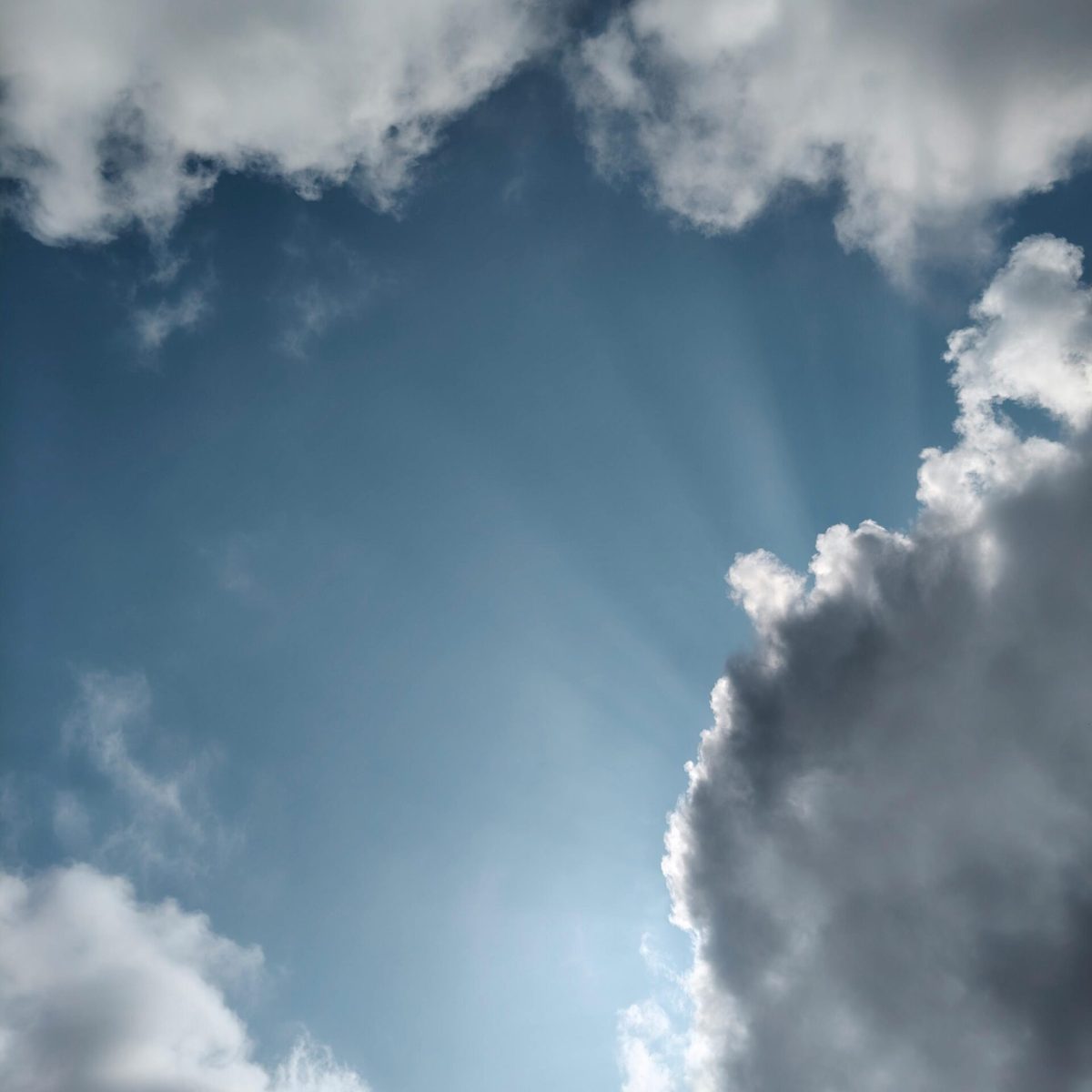 A captivating afternoon sky with sunlight rays shining through clouds in Silchar, Assam.