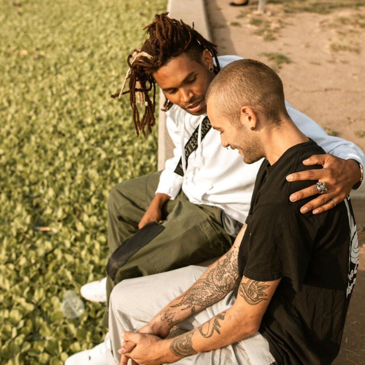 Two friends share a supportive moment outdoors, highlighting affection and companionship.